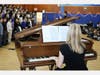 Tamaques band director Marisa Minogue accompanies on piano as choral director Benjamin Norkus conducts students in a winter concert in December.