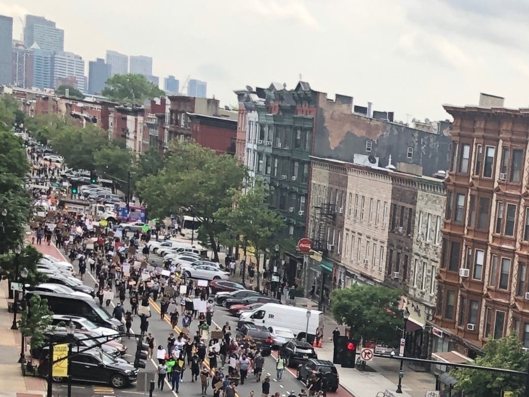 Protestors in Hoboken on Friday headed south along the Hudson River, and eventually marched north on Hoboken's main street, Washington Street. In far background: Jersey City skyline.
