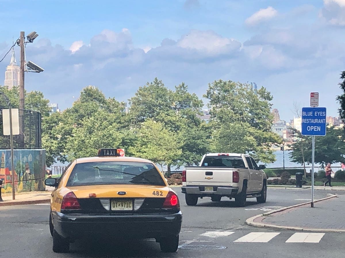 A taxi heads toward the south end of Sinatra Drive in Hoboken, along the Hudson River waterfront.