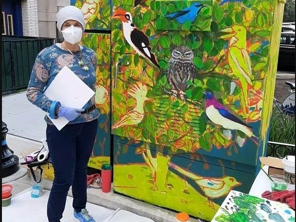 A resident adds to painter Alison Joseph's "The Hoboken Tree" on a utility box at Twelfth and Washington streets.