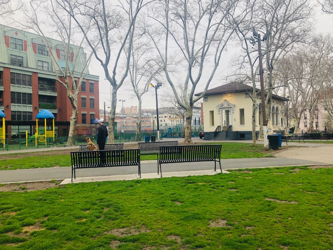Columbus Park: Grass, a toddler playground, a gazebo, and benches (pictured with a dog relaxing on a bench).