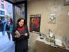 Vera Sirota reads a favorite poem. Behind her, a poster of the book cover, designed by Hoboken artist Chesleigh Meade.