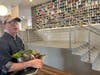 Dan Latham with vegetables from the roof. Behind him, a display of used paint cans from one of the artists who live in the building.