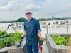 Dan Latham gathers vegetables for a fresh salad, with the skyline behind him.