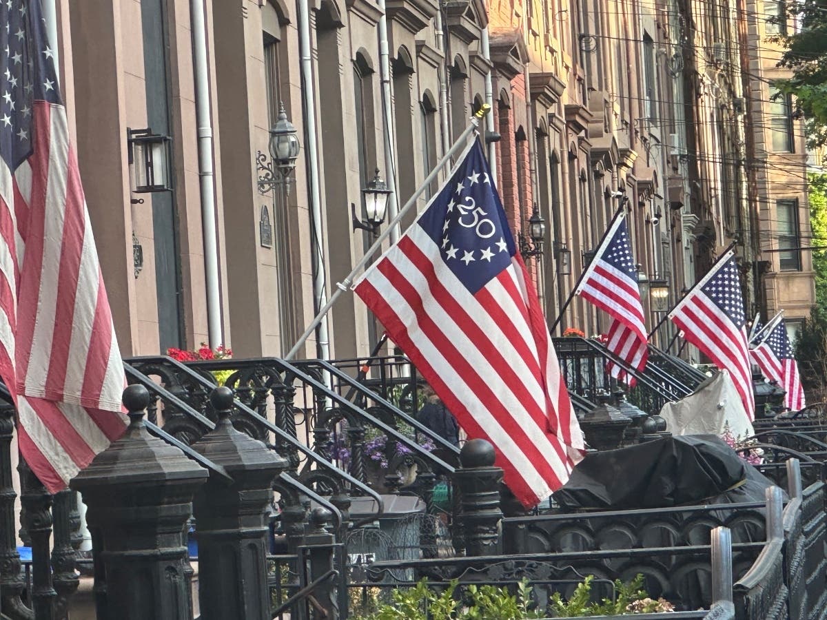 A row of homes in Hoboken with American and 250th flags.
