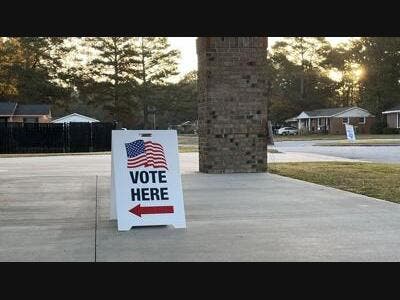 A sign directs voters to a polling location. 