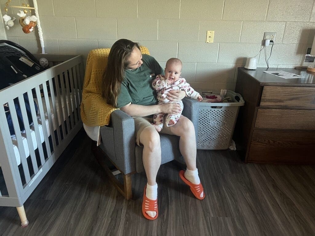 An incarcerated woman holds her infant daughter while seated in a rocking chair inside a shared room in the nursery unit at the Women’s Eastern Reception, Diagnostic and Correctional Center in Vandalia, Mo.
