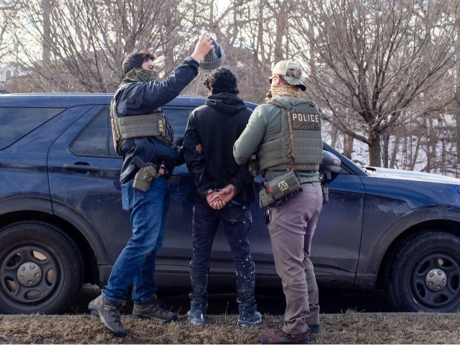  ICE agents search the passenger of a truck as they arrest both him and the driver during a traffic stop in February in Robbinsdale, Minn. Almost a quarter of ICE arrests in recent months have been “collateral,” a category that has raised legal questions.