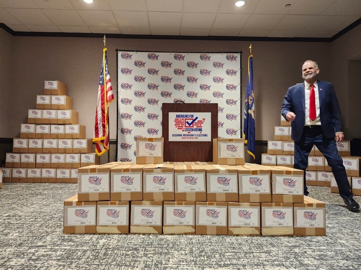 Kurt O’Keefe, one of the organizers behind Americans for Citizen Voting Michigan, a ballot committee dedicated to enacting voter ID and citizen-only voting in Michigan, lords over several boxes of petition signature sheets.