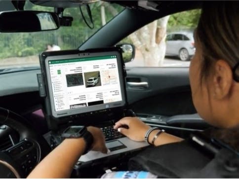 A police officer uses the Flock Safety license plate reader system.