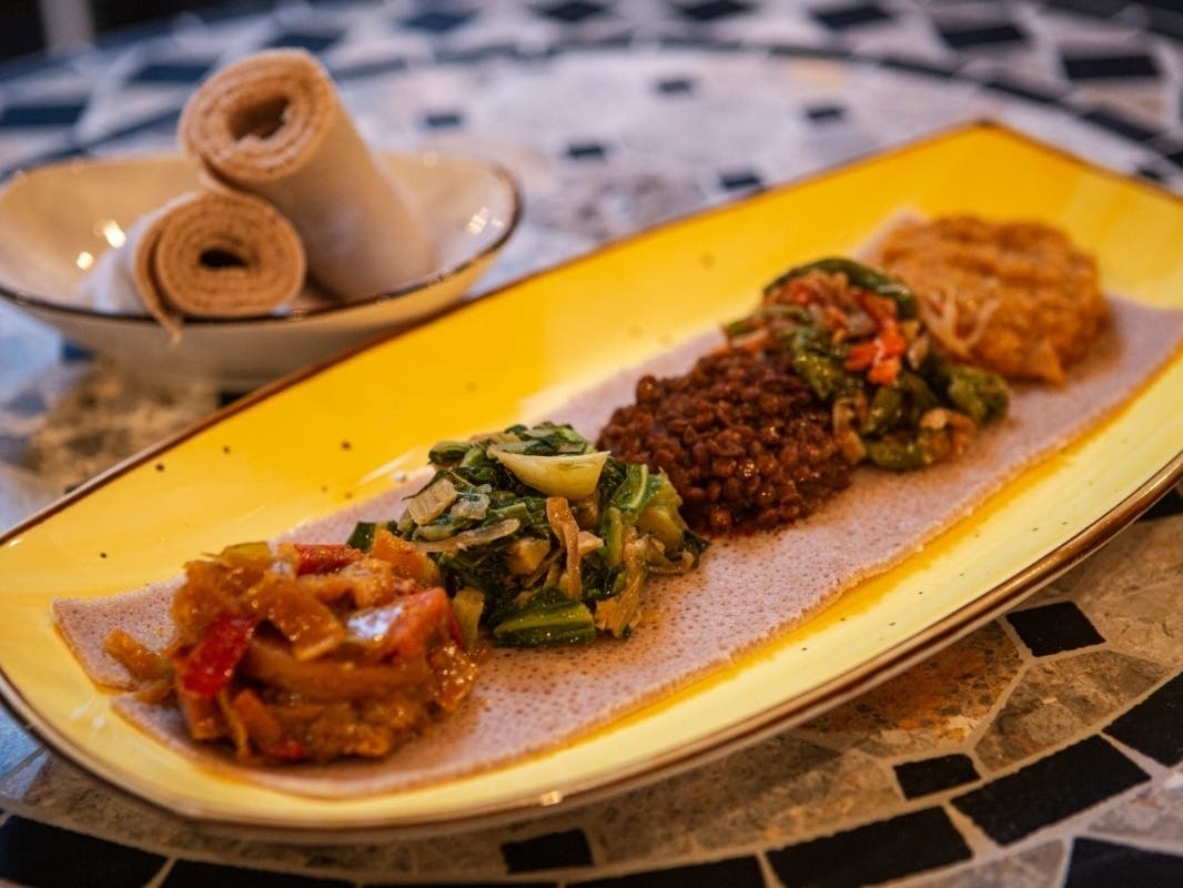 A platter at Ras Plant Based features an assortment of Ethiopian-based spreads served on a traditional flatbread.