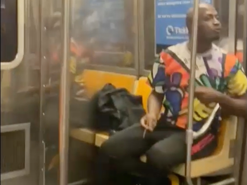 A video shows a man who police said spat on and threatened a father and daughter after being told to stop smoking marijuana on the train.