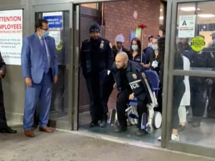 A wounded NYPD officer walks away from Lincoln Hospital in The Bronx after a Tuesday gunfight.