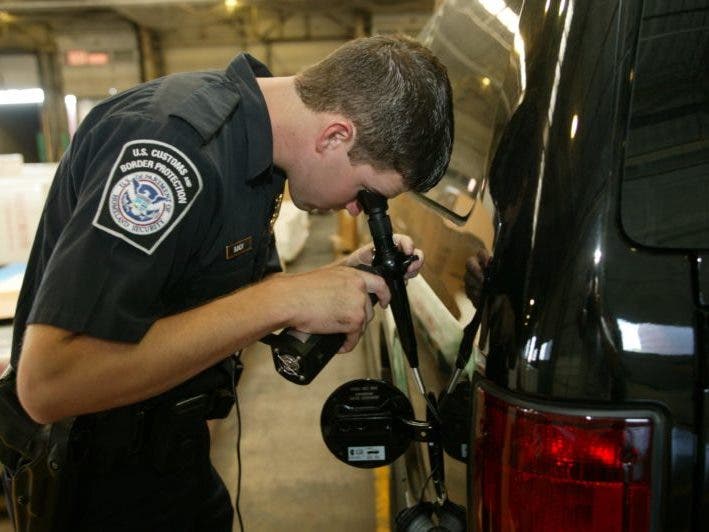 A Customs and Border Protection officer checks a vehicle for contraband. / Photo courtesy of Customs and Border Protection
