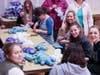 Mothers and daughters cutting, sewing and stuffing Teddy bears, serving together.