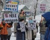 Protesters gathered for two hours, holding signs, speaking over bullhorns, and cheering as vehicles honked their horns on Baboosic Road.