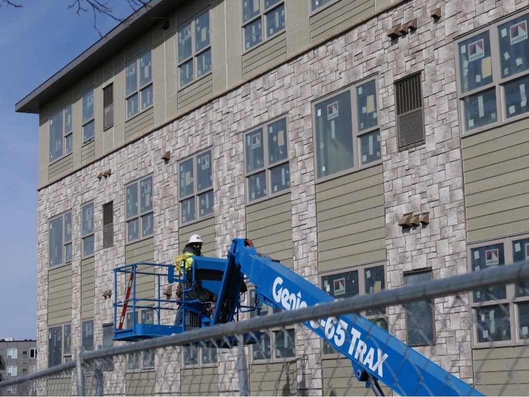 A worker installs siding on Pillsbury Ridge, an affordable housing development in Burnsville, in April 2025. 