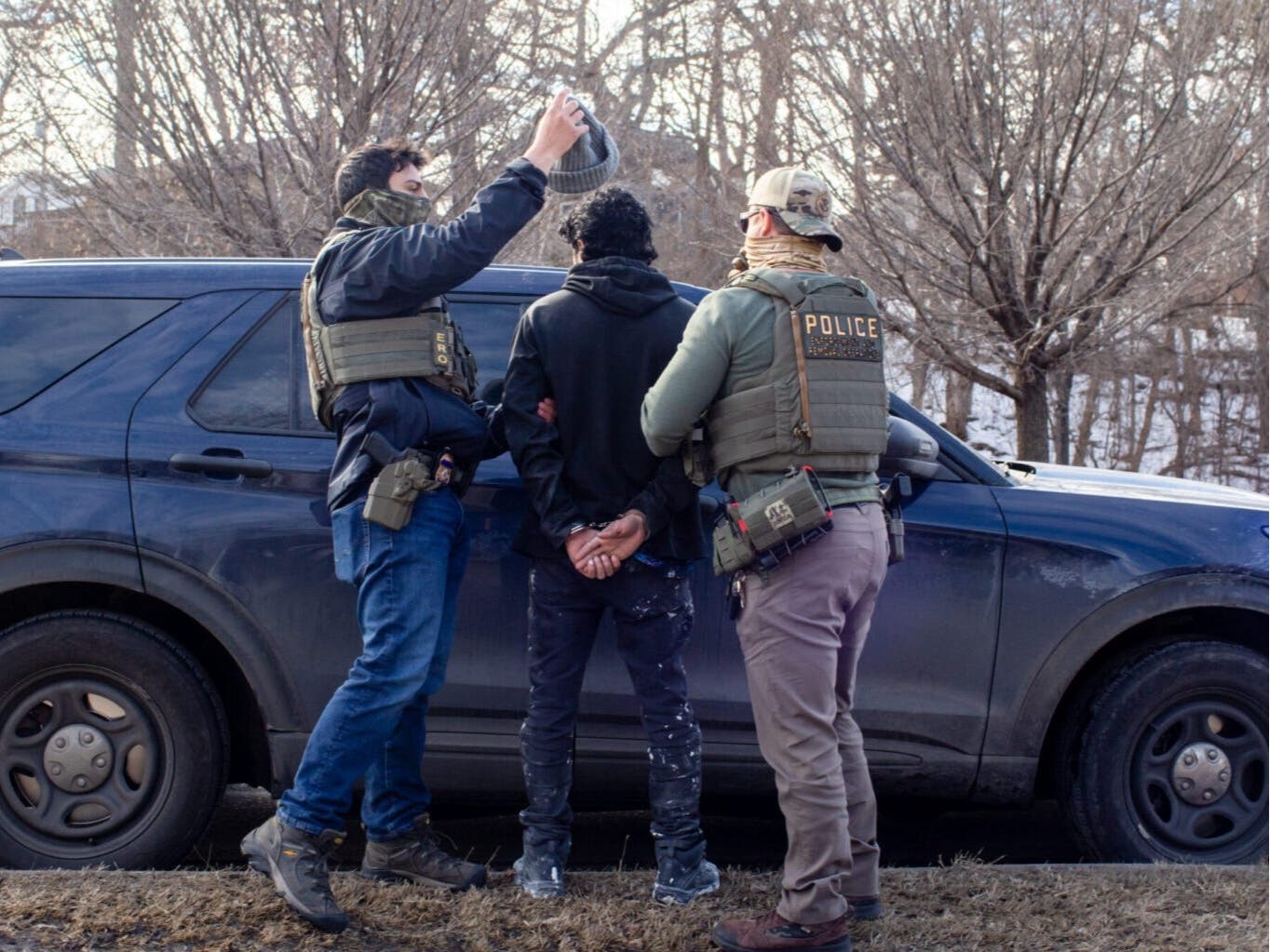 ICE agents search the passenger of a truck as they arrest both him and the driver during a traffic stop on Feb. 11, 2026 in Robbinsdale, Minnesota.