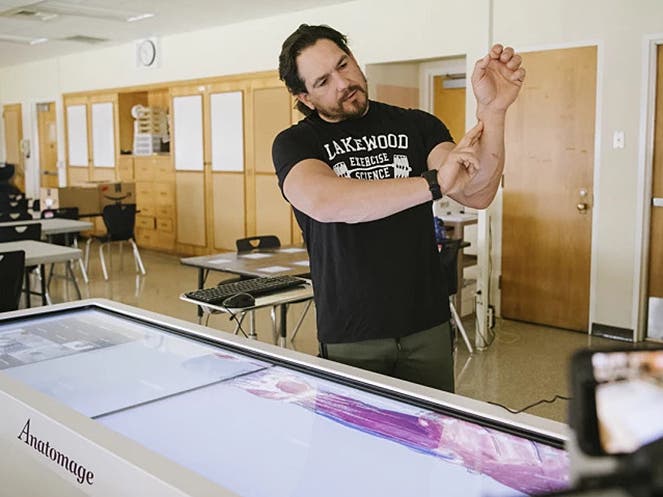 ONLINE LEARNING – Teacher Aaron Volkoff demonstrates via Zoom how to monitor a heart rate for the students in his Exercise Science class at Lakewood High School. Photo by Morgan Lieberman for Education Week.