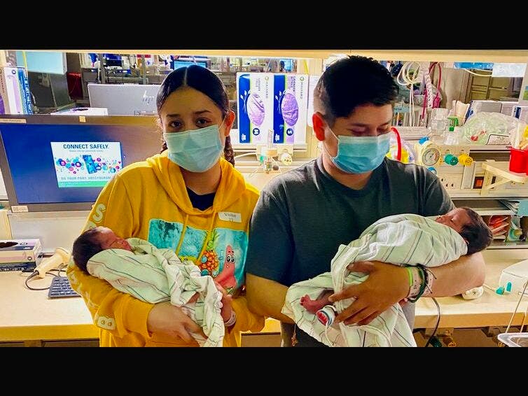 Violeta Andrade, who navigated blood cancer while pregnant with twins, is joined by her boyfriend, Marco Benitez, to hold their newborn babies in the neonatal intensive care unit of the LLU Medical Center.