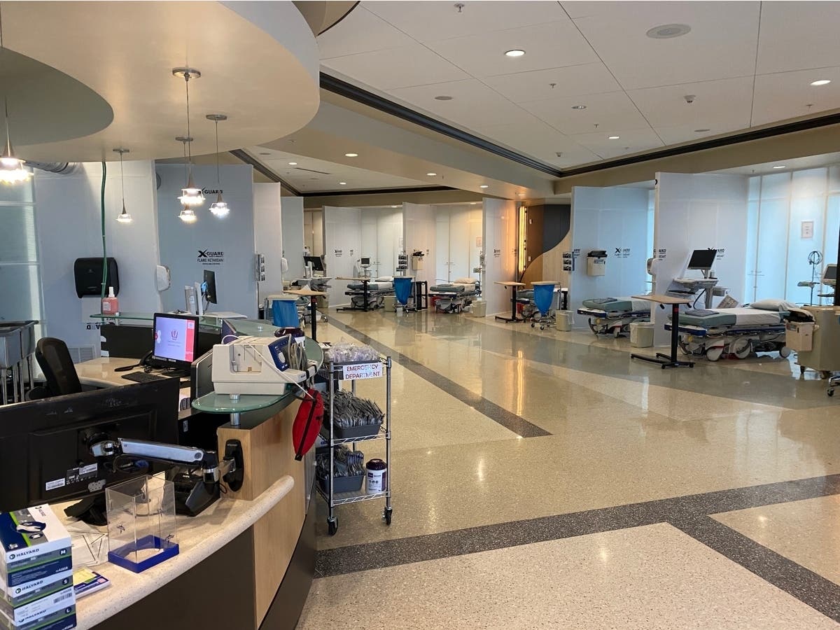 Pictured here is a COVID unit from the converted lobby including beds, sanitization stations and medical supplies. The new space utilizes makeshift walls and ventilation to be isolated mechanically from the rest of the hospital.