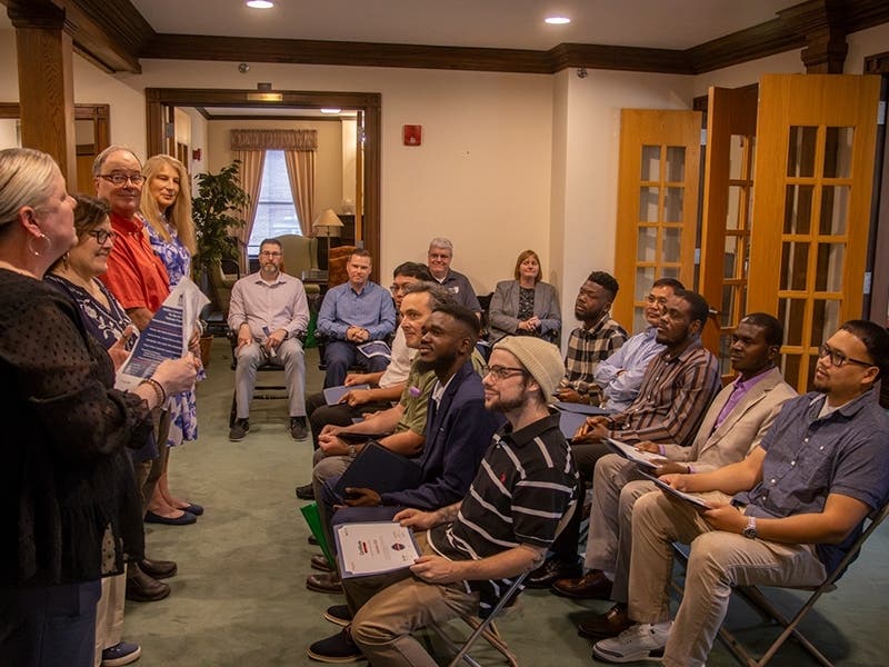 Students sit with their diplomas at the Pathmaker Program Graduation.