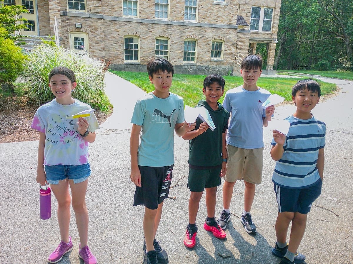 College for Kids aviation students with paper airplanes.