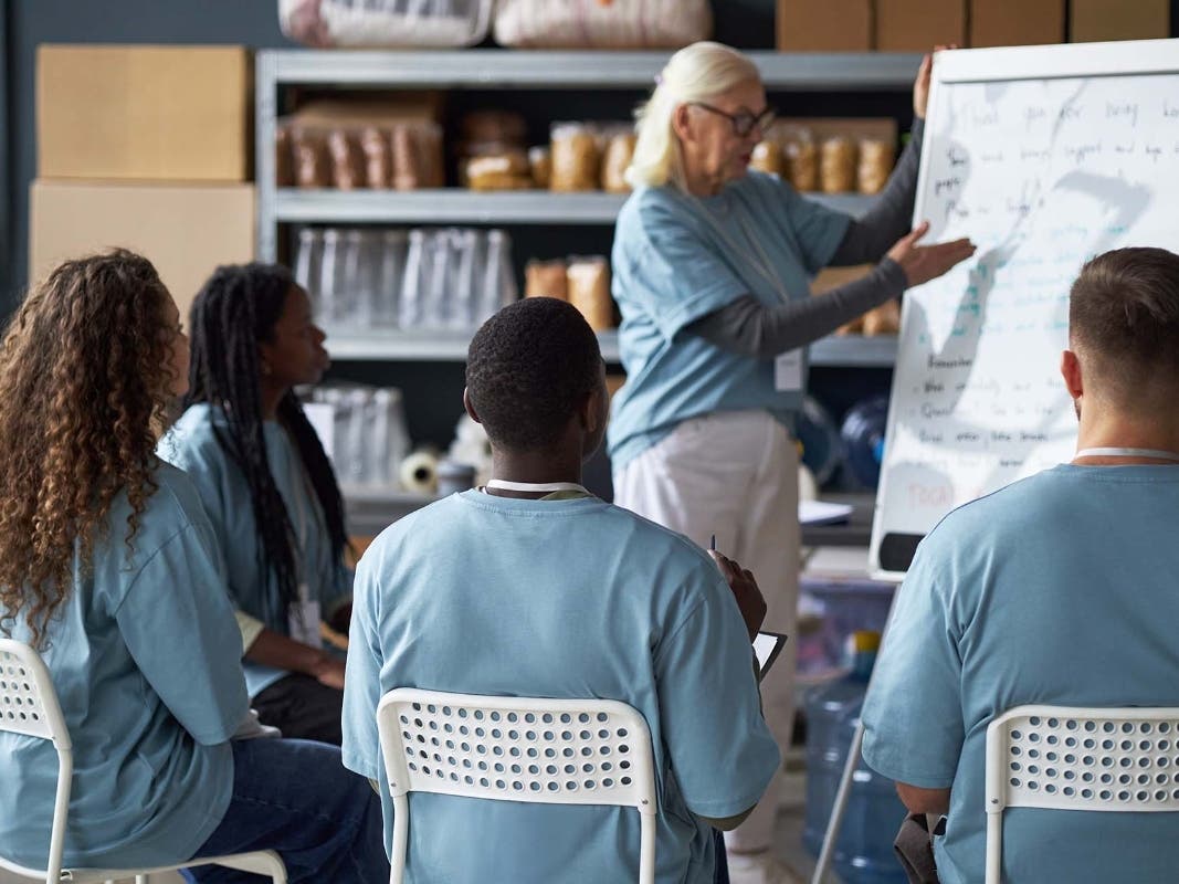 Senior Woman Delivering Training Session in Classroom