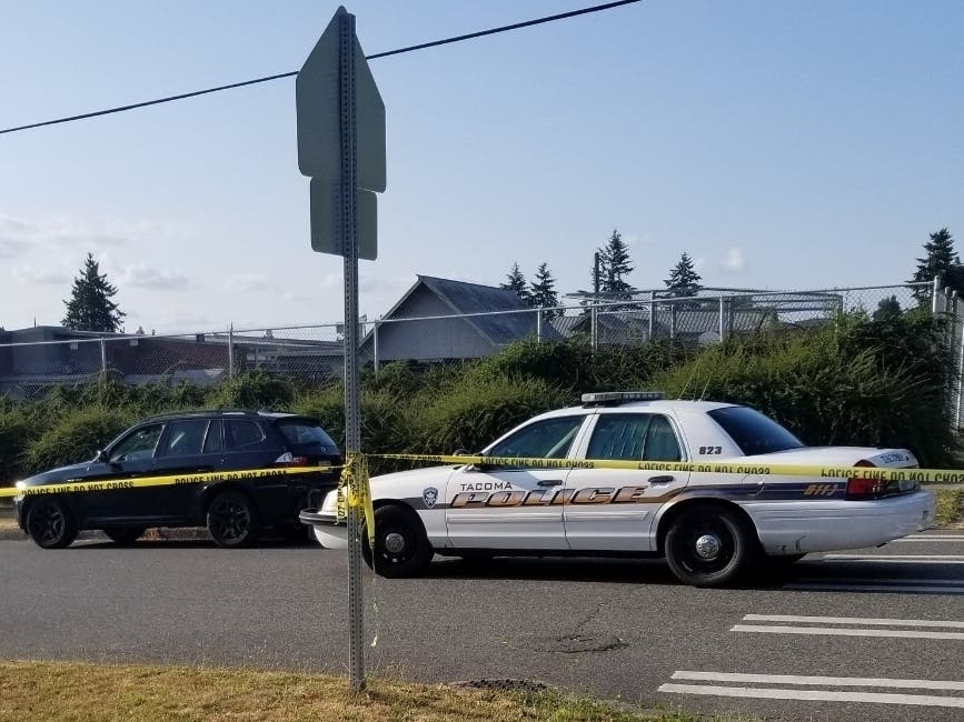 Officers surround the black SUV which contained the first victim, deceased from a gunshot wound.. 
