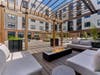 Two landscaped courtyards at Citizen Linden in Linden, NJ serve as a hub of outdoor activity with lounge seating areas, BBQ and dining sections, firepits, a central fountain, a bar with a television, and a Zen relaxation area. 