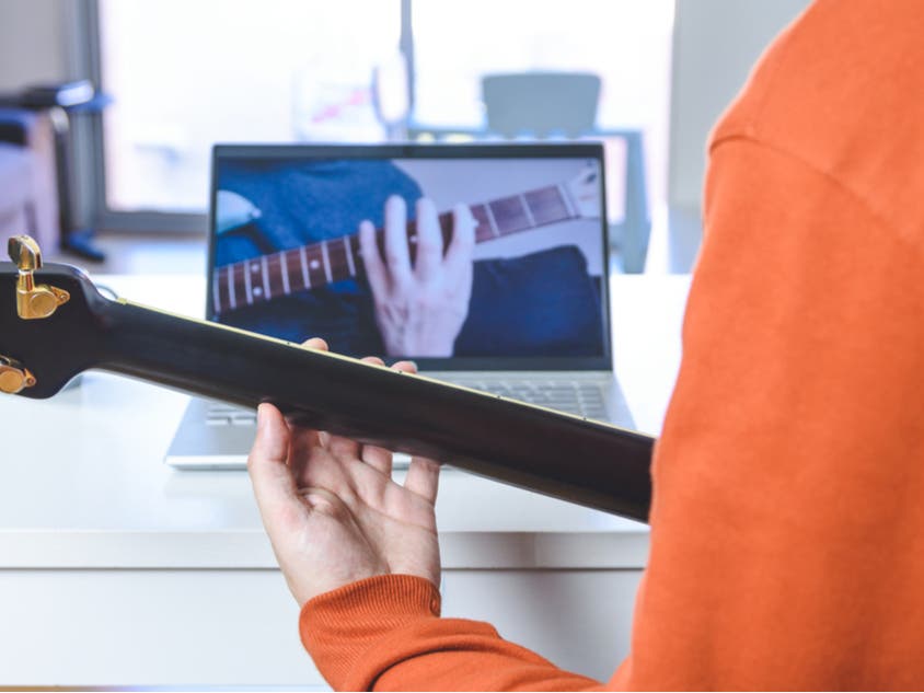 Student watching online guitar lesson