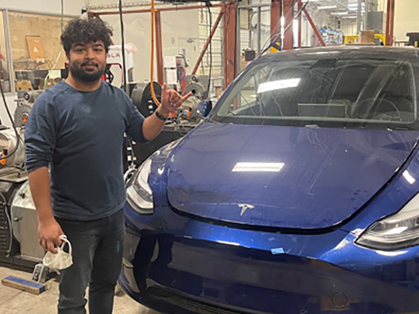 Vikram Gupta with a Tesla car. (Courtesy: UTA)