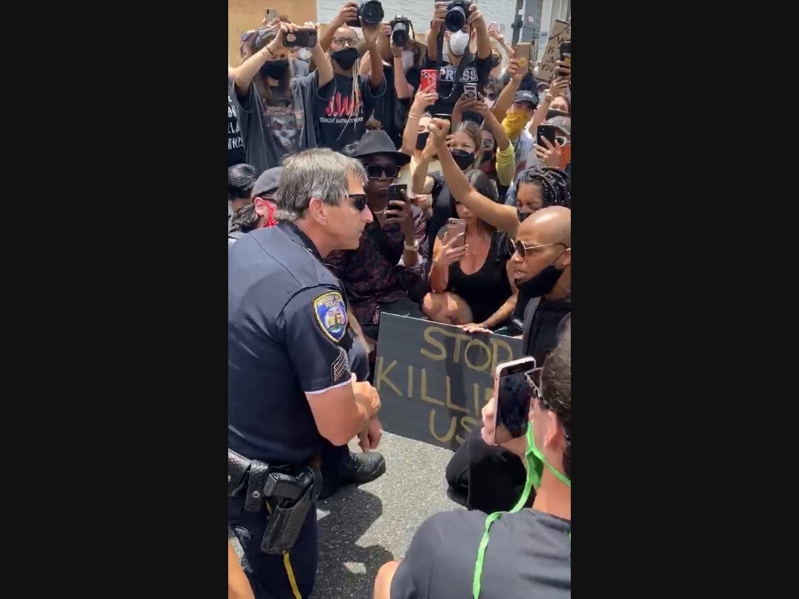 A Beverly Hills Police officer speaks to protesters on Tuesday.