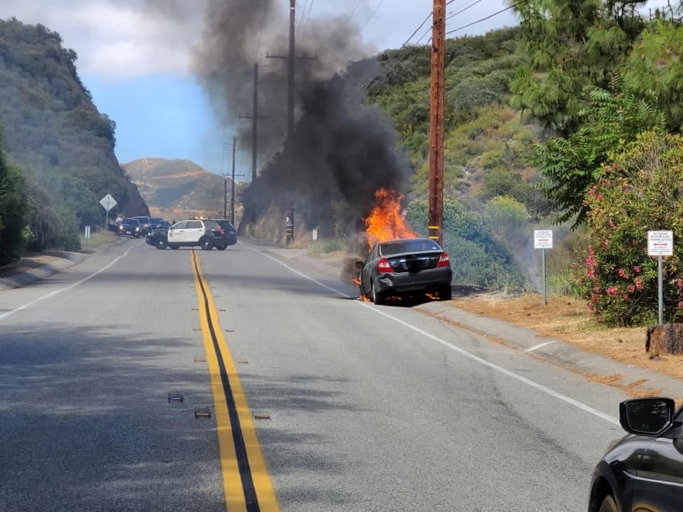A black Toyota Camry caught fire on Mullholland Drive.
