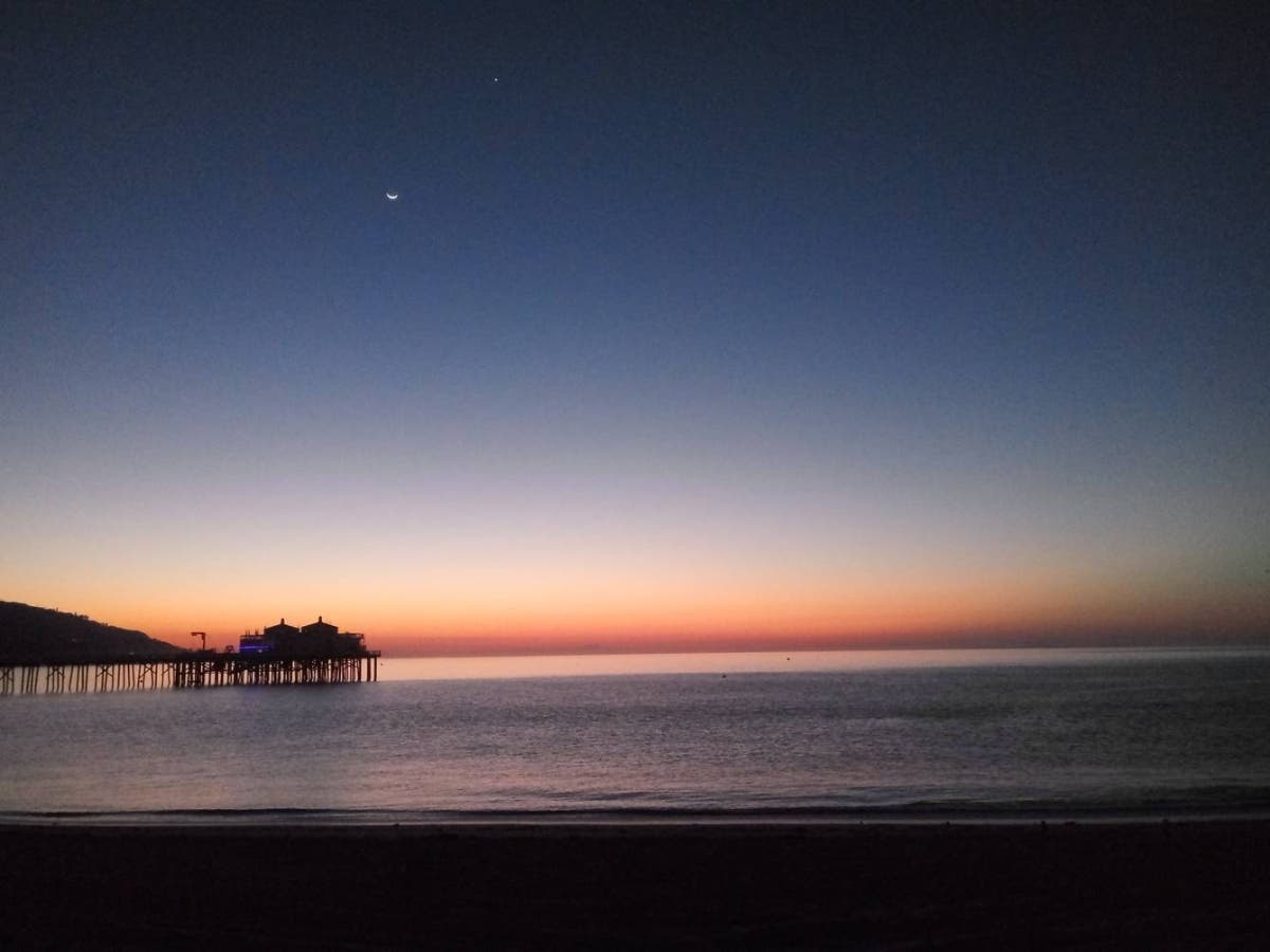 Orange, periwinkle, and midnight blue mingle majestically together over Surfrider Beach.