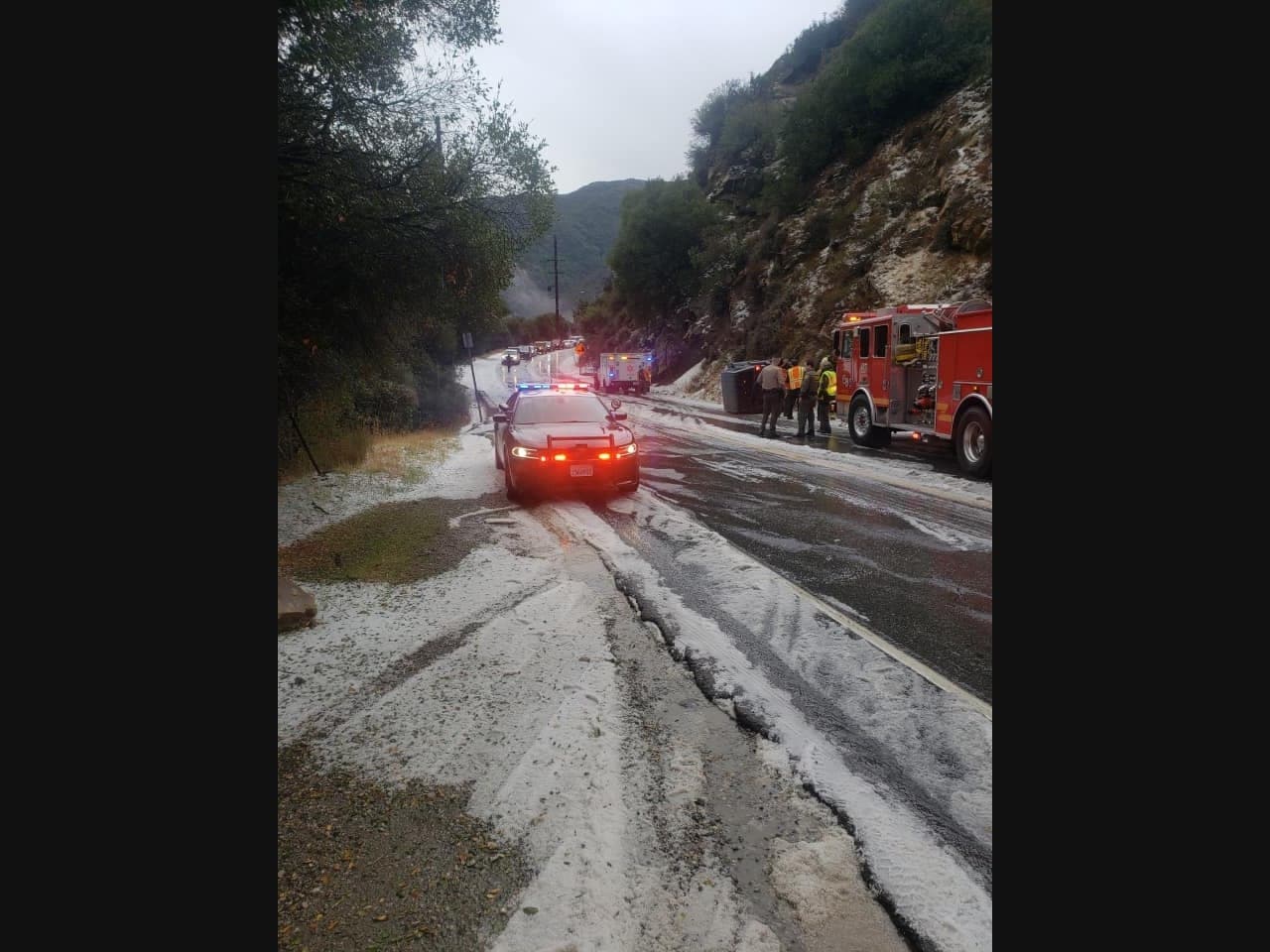 Lost Hills deputies and LA County firefighters attend to a flipped over car.