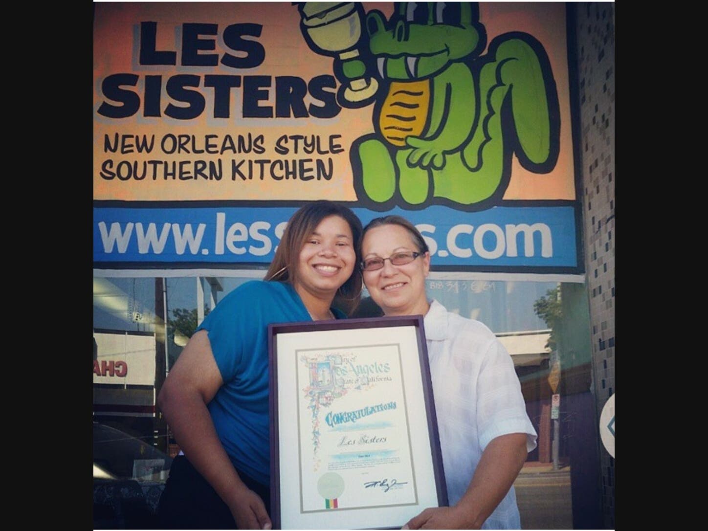 Jessica Huling and Susan Warner - the restaurant's first waitress and eventual co-owner - hold an award in front of the restaurant.