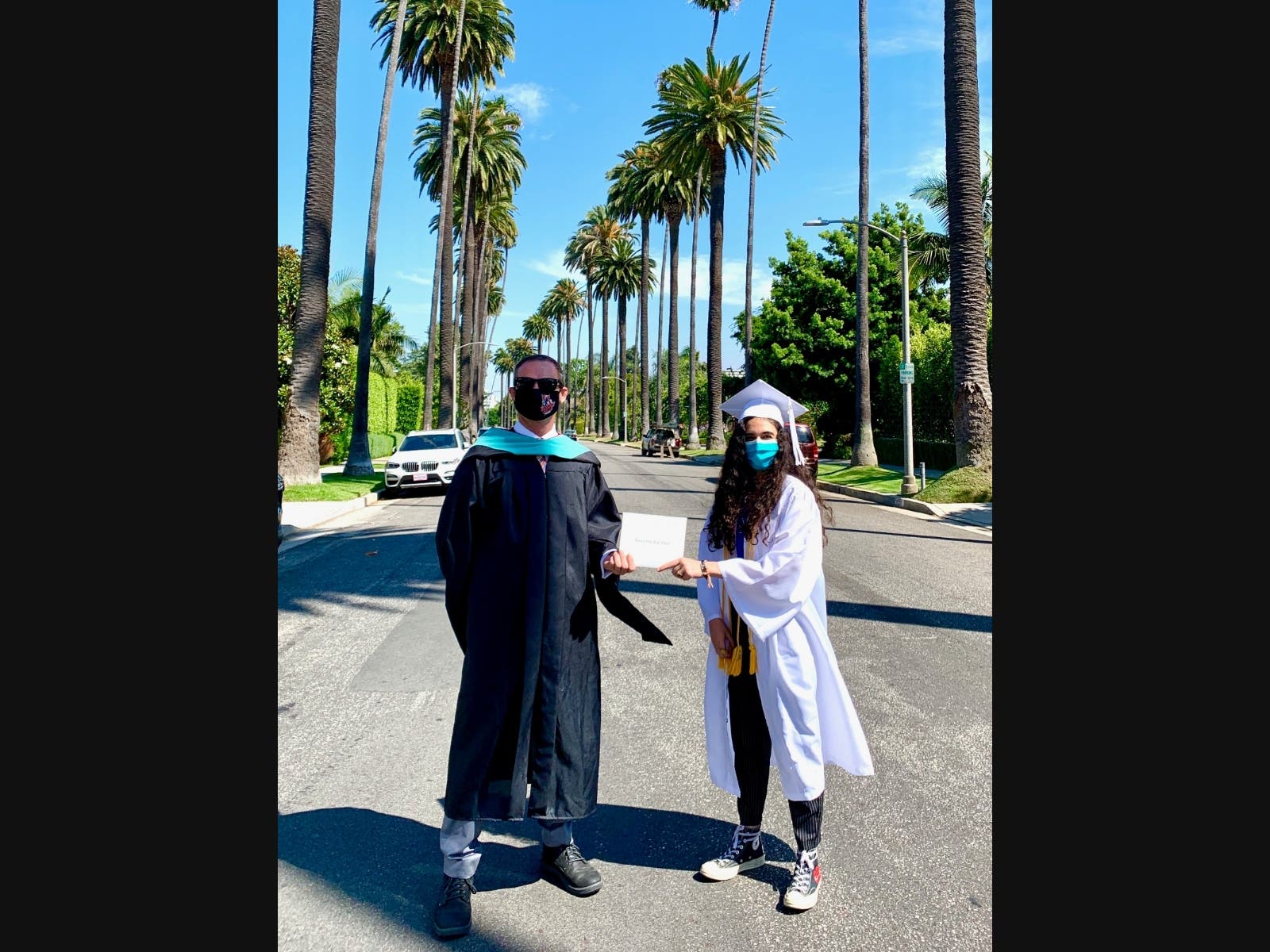 Beverly Hills High School Principal Mark Mead hand delivers a diploma to graduate Leila Nourmand on June 12, 2020.