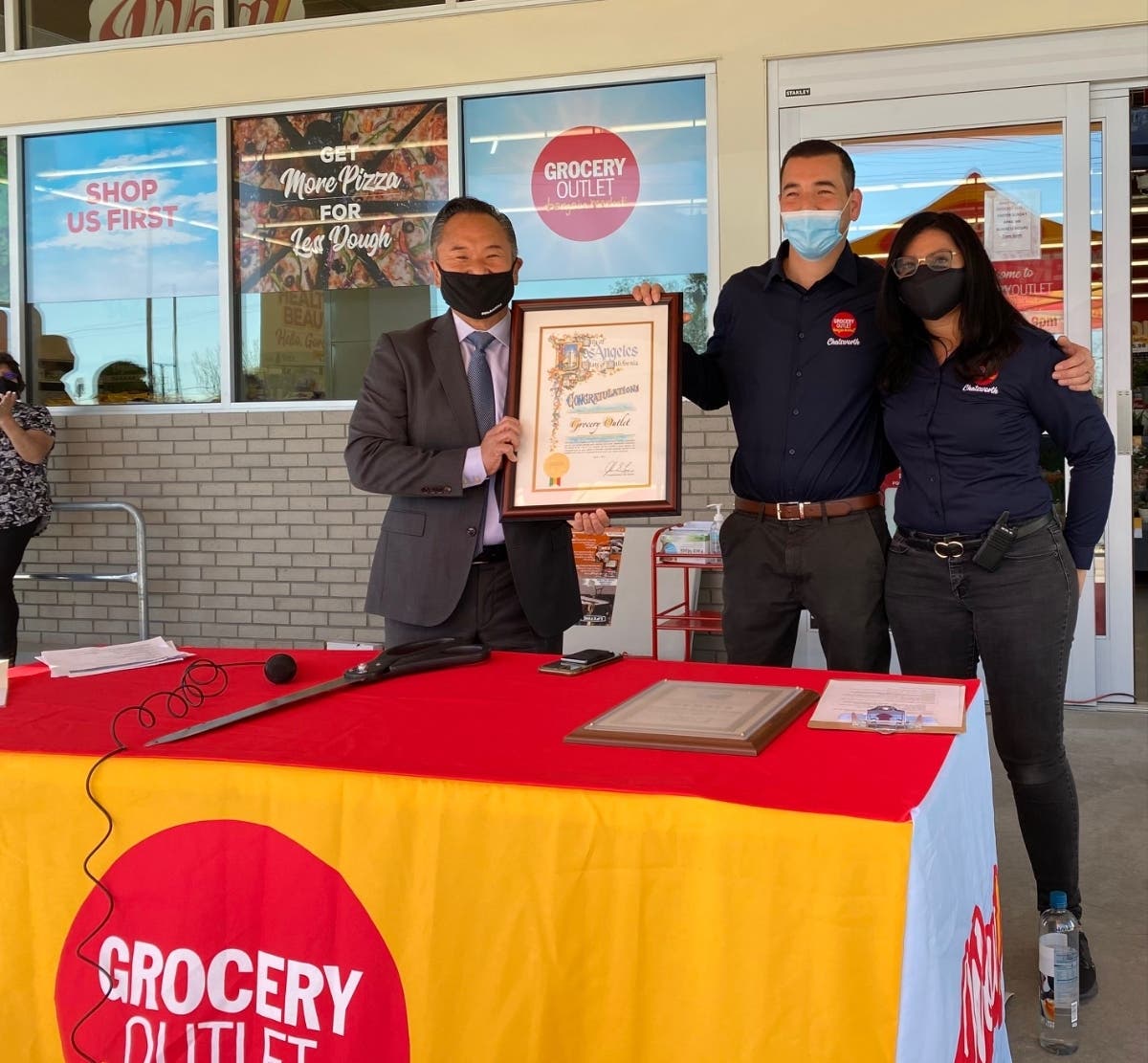 Councilmember John Lee with owners Christopher and Lisette Herrera.