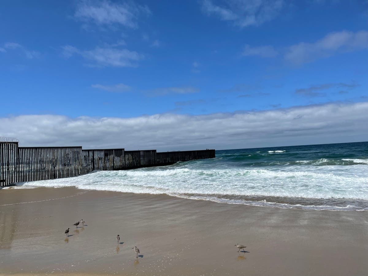 A woman was stranded on the border fencing that extends 300 feet into the ocean. 