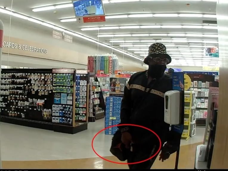 The suspect is described as a Black male, 30-35 years old, 5’7”, medium build, wearing a black and gold Louis Vuitton bucket hat, black and gold sunglasses, a black mask, a black and gold sweater, and black sweatpants. 
