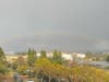 A faint rainbow is visible over the storm clouds. 