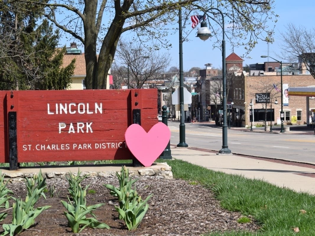  A red heart, symbolizing support for frontline and essential workers, adorns the Lincoln Park sign on Main Street in St. Charles.