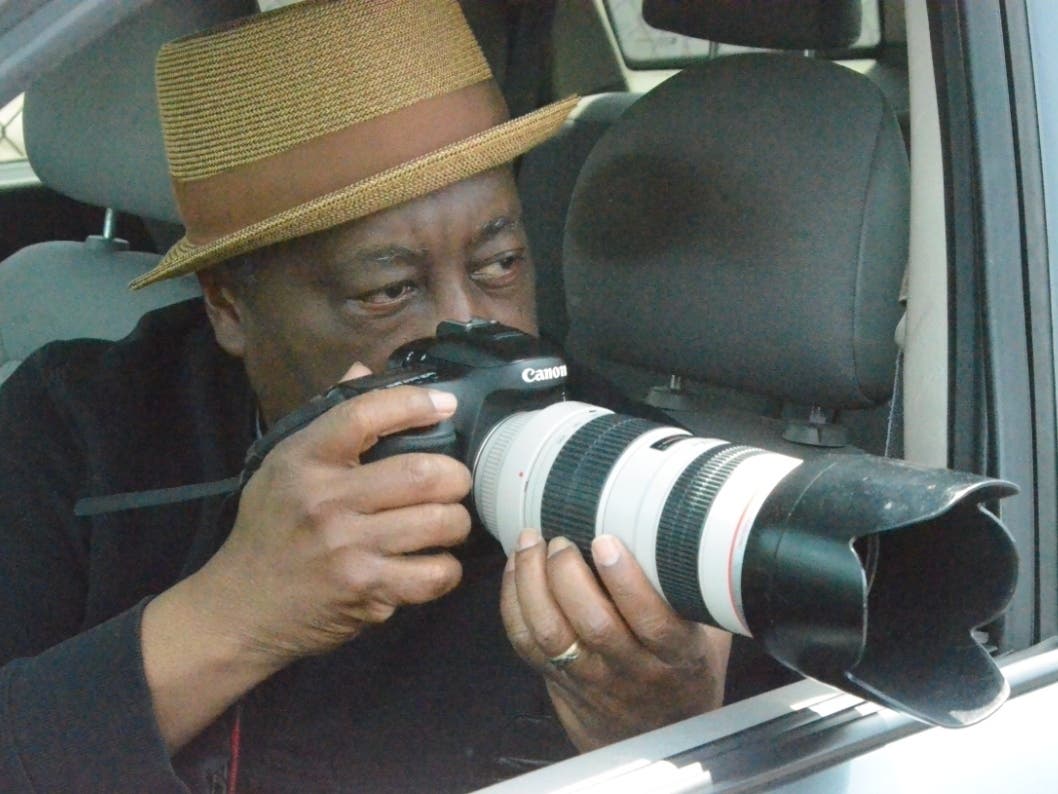 Aurora photographer Donnell Collins sets up a shot while doing his "Driveby Photo Shoot Project." 