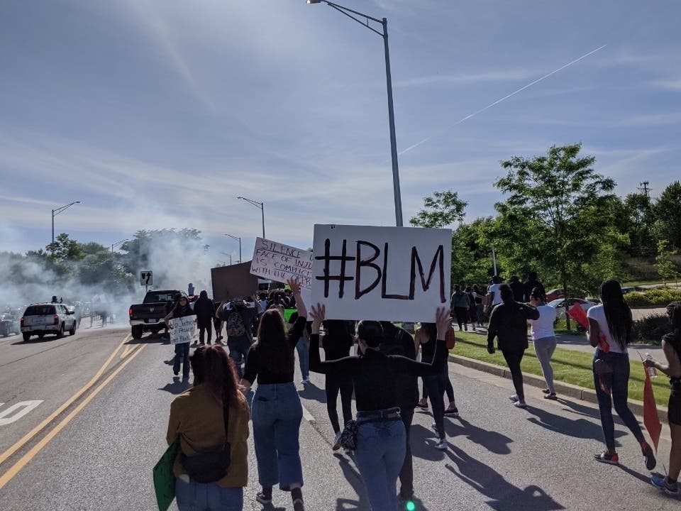 Protesters march past the Aurora Police Department on Sunday. 