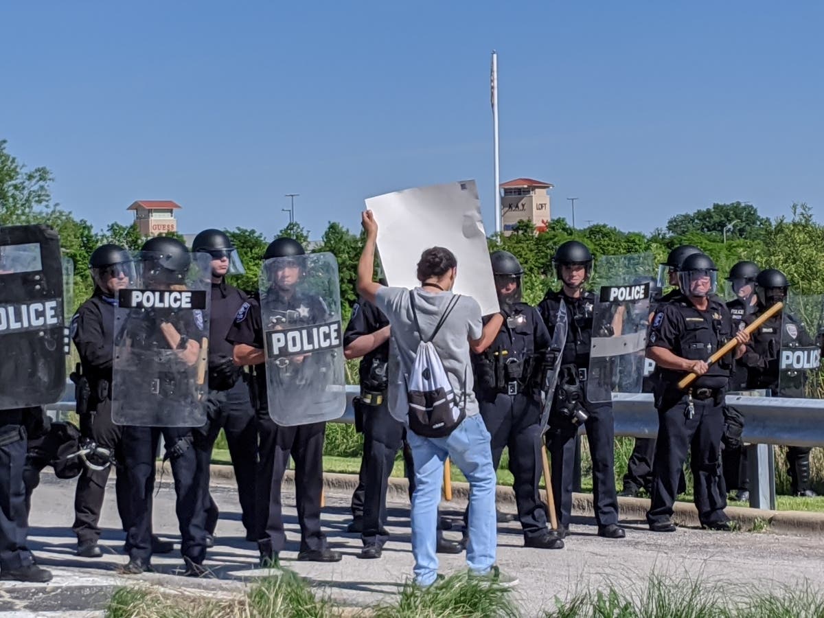 A protester demonstrates in front of police May 31 outside the Chicago Premium Outlets mall.