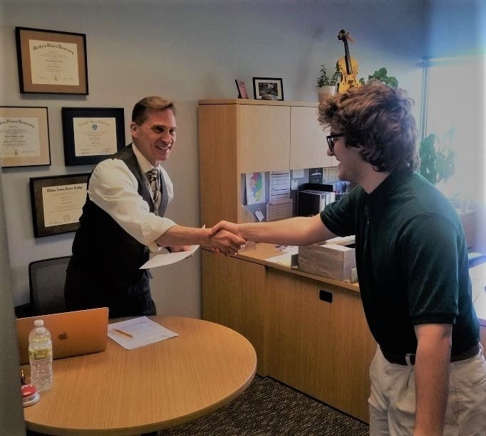 Dr. Kevin Jauch shakes hands with student Karim A. during mock job interview