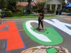 A volunteer paints the street mural of Black Lives Matters in front of the Dr. Carter G. Woodson African American Museum on Thursday, June 18. 