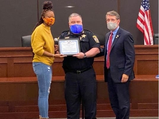 Kyla Davis (left) receives a Good Samaritan award from Police Chief Nick Pecora and Mayor Tom Hayes. 