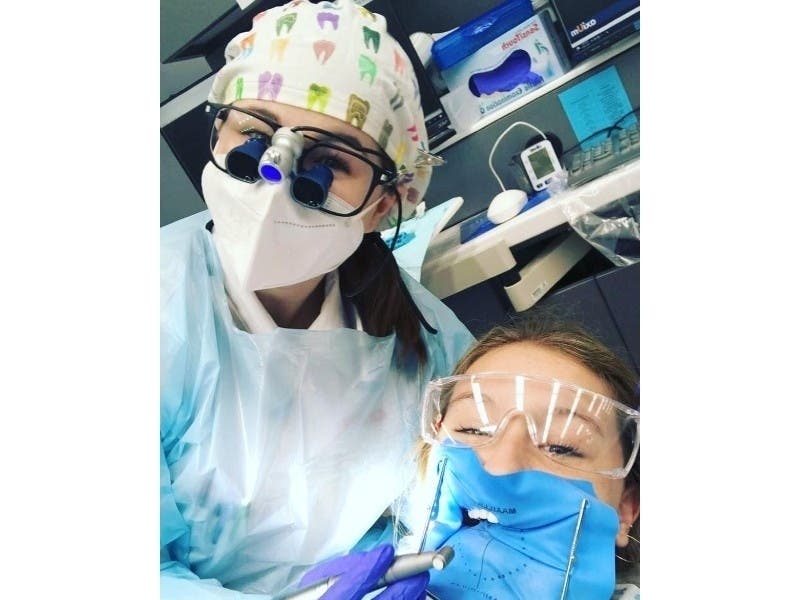 Caitlin Neubauer (left) drills the tooth of her sister, Greta, both students at Creighton University and Saint Viator graduates. 